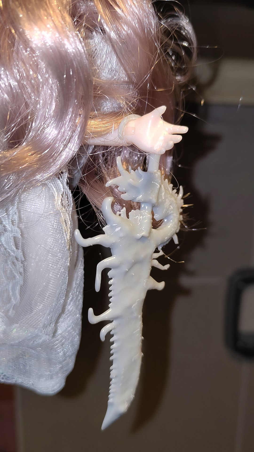 close up of the 3d printed sword on the hands of the left hand of the doll