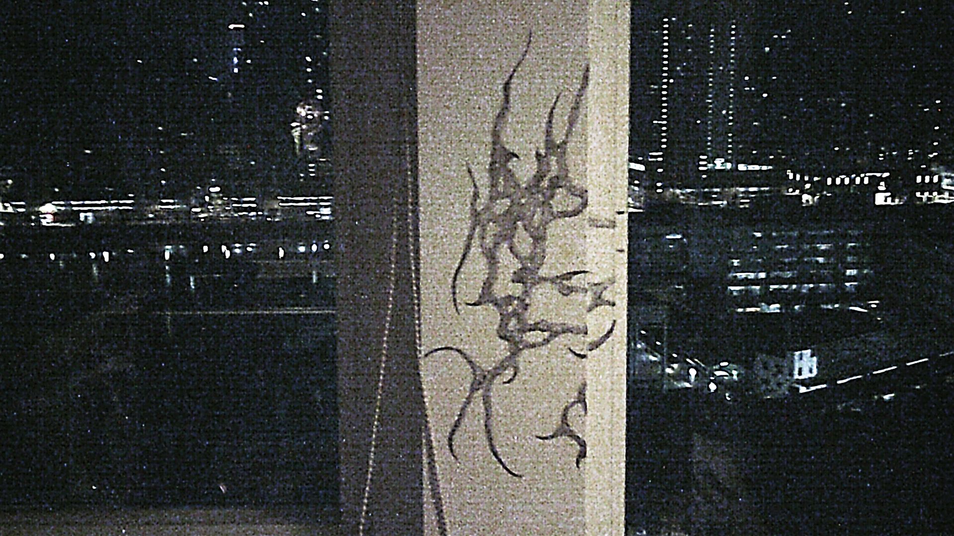 close up of pencil drawing an organic shape with differnt shades of grey holding to the window frame like an alien organic creature